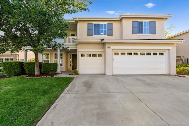 traditional-style home featuring a balcony, a garage, concrete driveway, stucco siding, and a front lawn