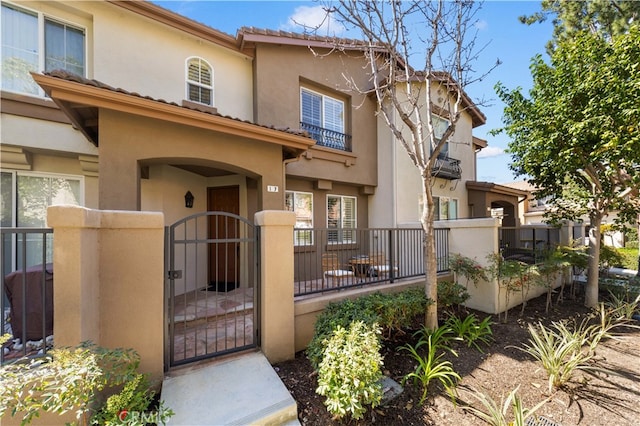 view of front of property featuring a fenced front yard, stucco siding, and a gate