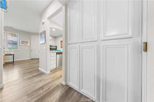 corridor featuring baseboards and light wood-style flooring