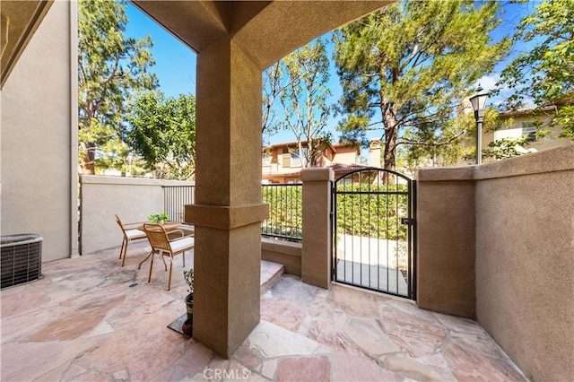 view of patio / terrace with cooling unit, fence, and a gate