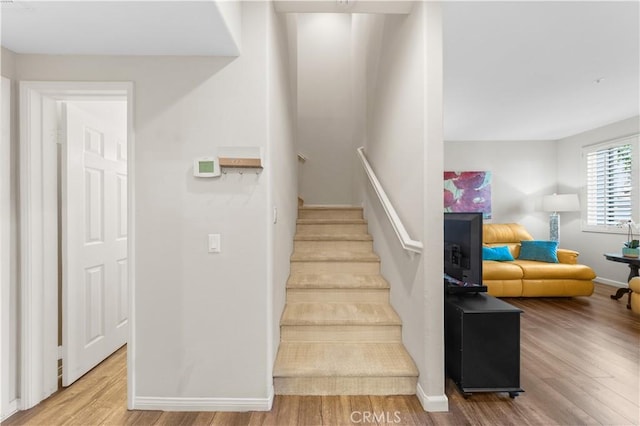 stairway with baseboards and wood finished floors