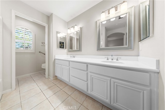 full bathroom featuring tile patterned floors, toilet, double vanity, and a sink