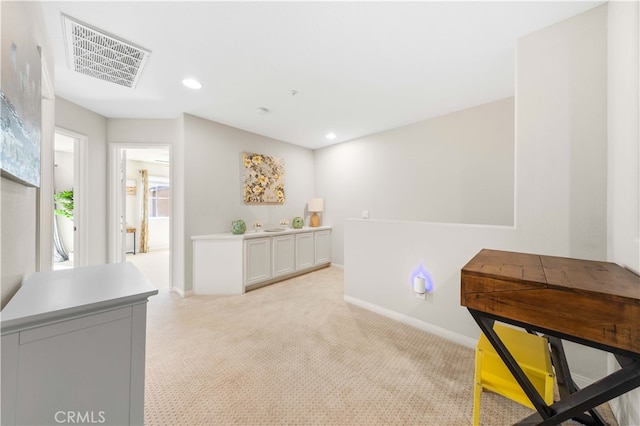 interior space featuring recessed lighting, visible vents, light carpet, and baseboards