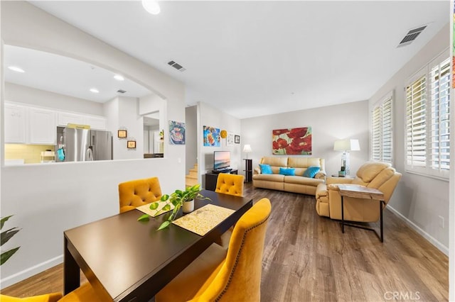 dining area with visible vents, baseboards, and wood finished floors