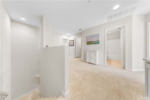 corridor with visible vents, baseboards, recessed lighting, an upstairs landing, and light colored carpet