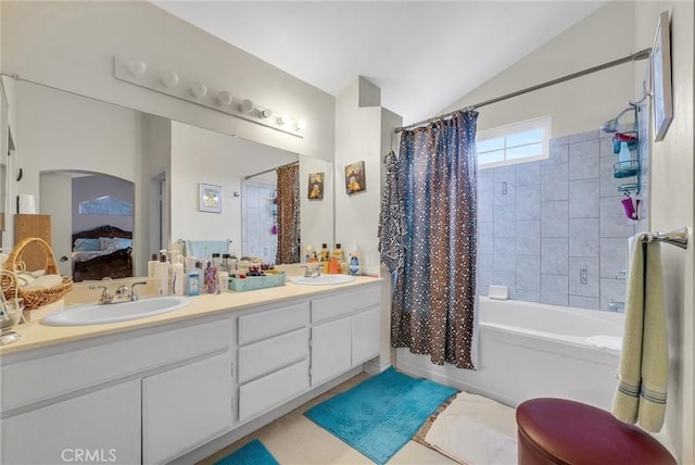 bathroom featuring double vanity, shower / bathtub combination with curtain, vaulted ceiling, and a sink