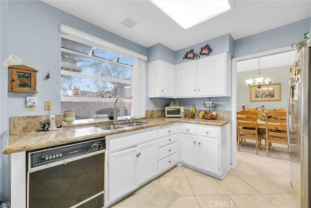 kitchen featuring light stone counters, freestanding refrigerator, white cabinets, a sink, and dishwasher