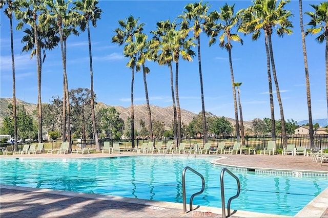 pool featuring a patio area, fence, and a mountain view