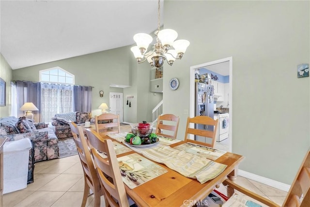 dining area featuring light tile patterned floors, baseboards, stairway, high vaulted ceiling, and a notable chandelier