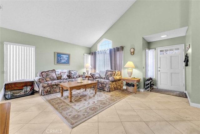 living room with light tile patterned floors, high vaulted ceiling, and baseboards