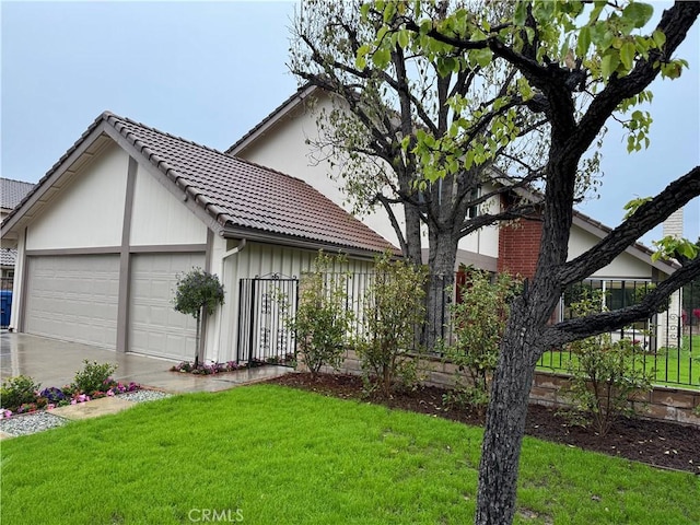 view of front of home featuring a tile roof, fence, a garage, and a front lawn