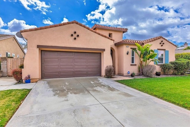 mediterranean / spanish-style house with an attached garage, a tile roof, driveway, stucco siding, and a front lawn