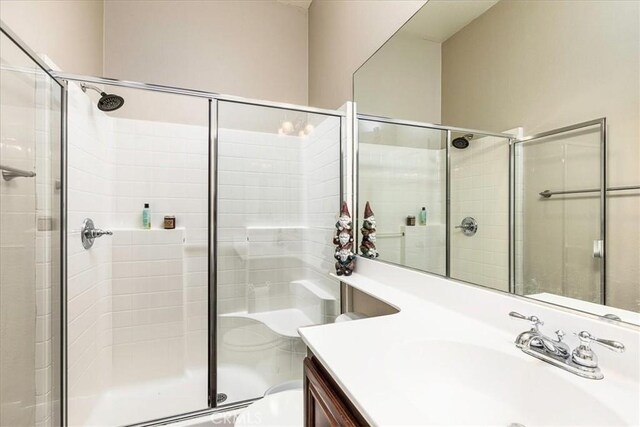 full bath featuring toilet, a shower stall, and vanity