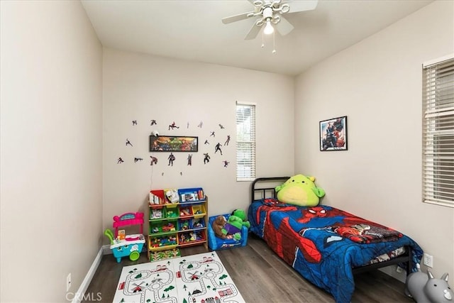 bedroom featuring ceiling fan, baseboards, and wood finished floors