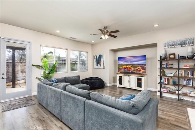 living room featuring baseboards, wood finished floors, and recessed lighting