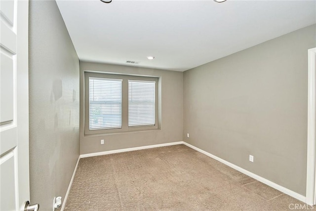 carpeted empty room with visible vents and baseboards