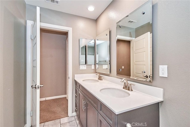 bathroom featuring visible vents, a sink, and double vanity