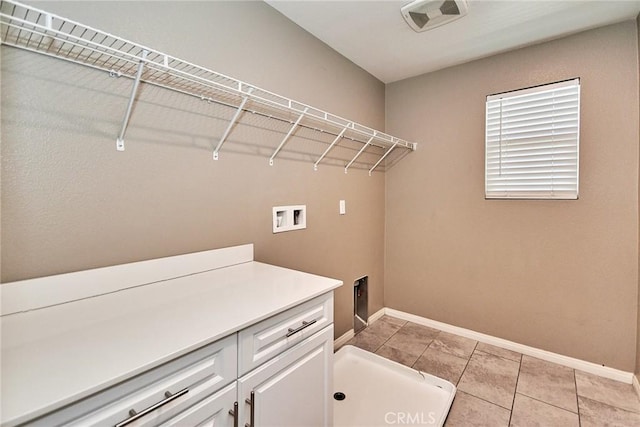 clothes washing area featuring washer hookup, light tile patterned floors, cabinet space, visible vents, and baseboards