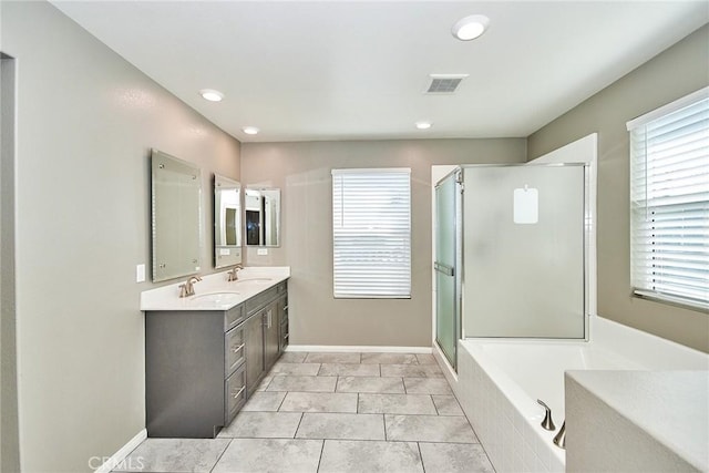 full bathroom featuring double vanity, a stall shower, baseboards, visible vents, and a sink