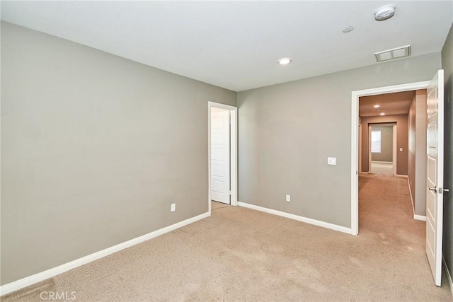 spare room with light carpet, visible vents, and baseboards