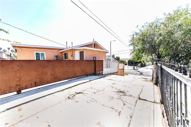 back of house featuring a fenced front yard and stucco siding