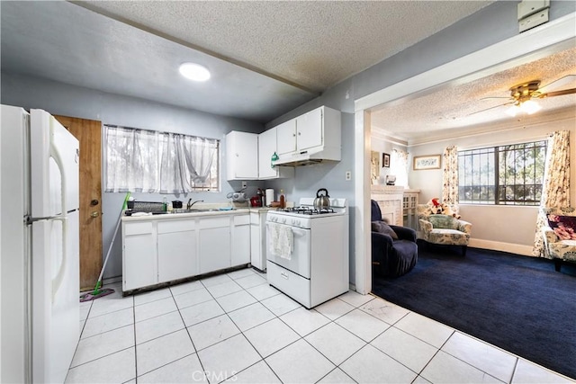 kitchen with light countertops, open floor plan, light tile patterned flooring, white cabinetry, and white appliances