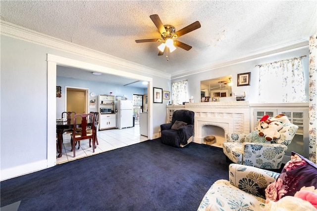 carpeted living room featuring ceiling fan, a textured ceiling, crown molding, and tile patterned floors