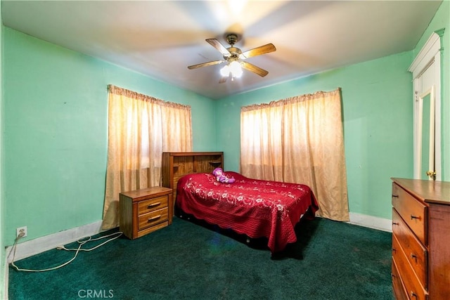 bedroom with dark colored carpet, a ceiling fan, and baseboards