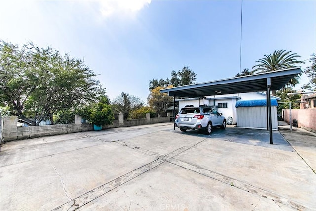 view of parking / parking lot with fence and driveway