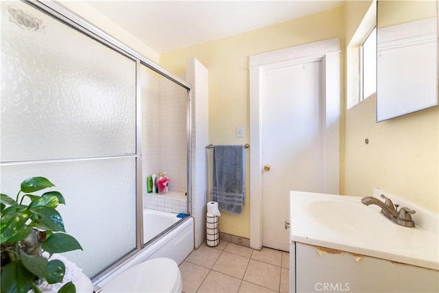 bathroom featuring vanity, shower / bath combination with glass door, tile patterned flooring, and toilet