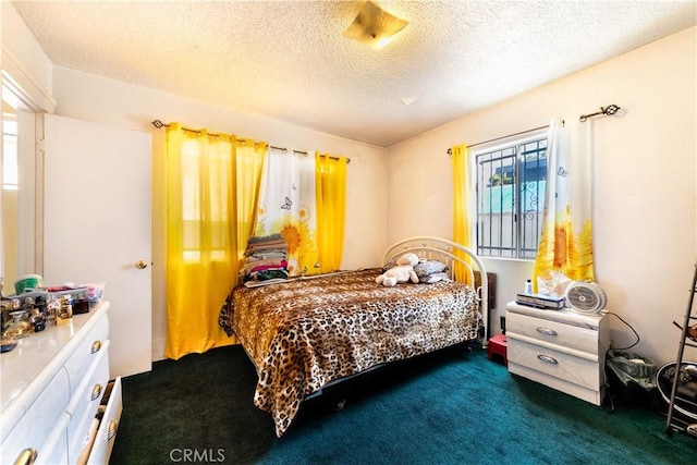 bedroom with dark carpet and a textured ceiling