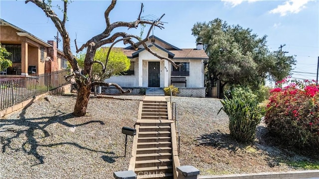 bungalow-style house with fence and stucco siding