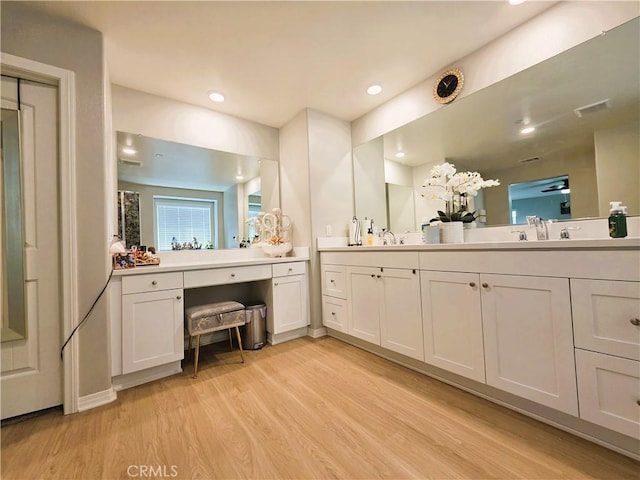 full bathroom featuring recessed lighting, a sink, wood finished floors, visible vents, and double vanity