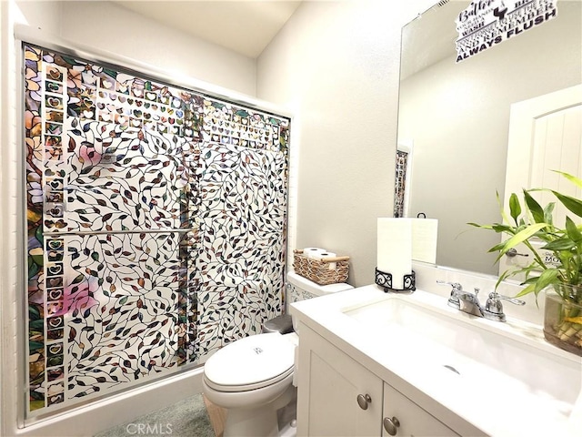 bathroom with vanity, a shower stall, and toilet