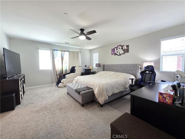 bedroom featuring carpet floors, multiple windows, baseboards, and a ceiling fan