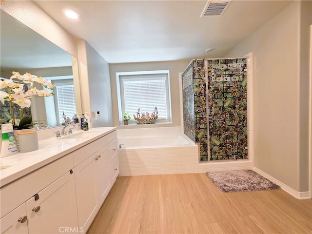 bathroom featuring a wealth of natural light, wood finished floors, and visible vents