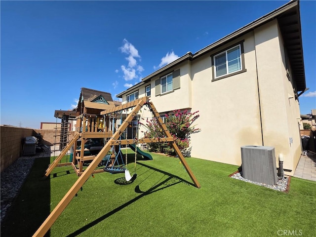 view of play area with a fenced backyard, cooling unit, and a lawn