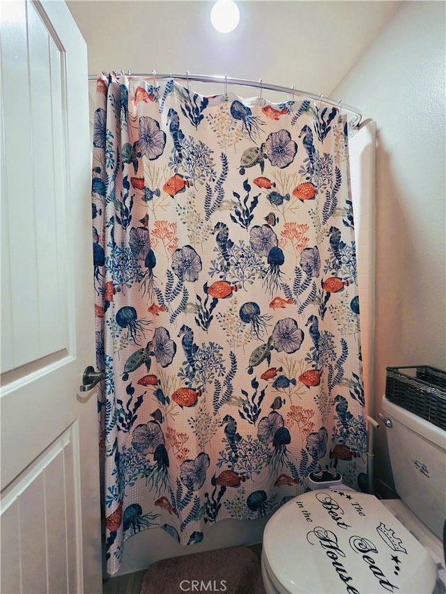 full bath featuring toilet and a shower with curtain