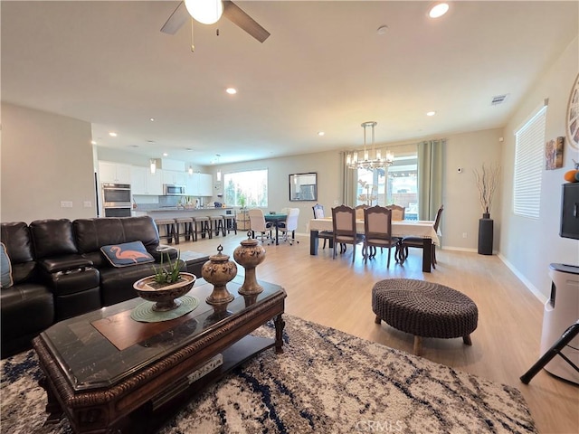 living room with a wealth of natural light, light wood-style flooring, and recessed lighting