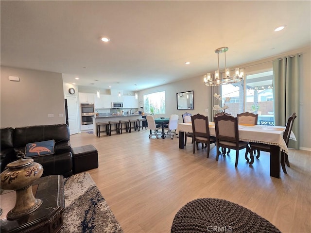 dining room featuring light wood-style floors, a notable chandelier, and recessed lighting