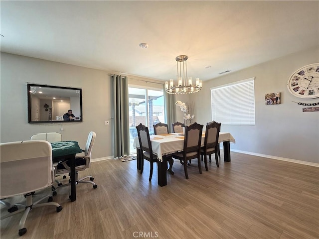 dining space with baseboards, visible vents, and wood finished floors