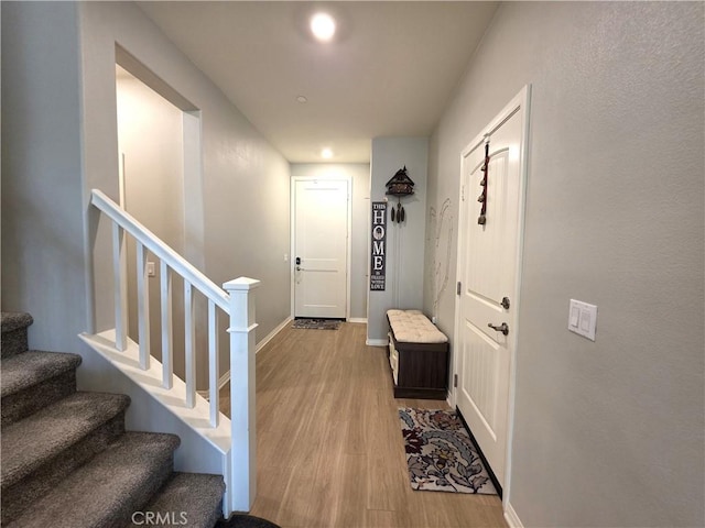 interior space with stairway, wood finished floors, and baseboards