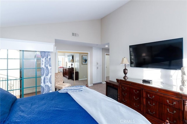 carpeted bedroom with a closet, visible vents, vaulted ceiling, and baseboards