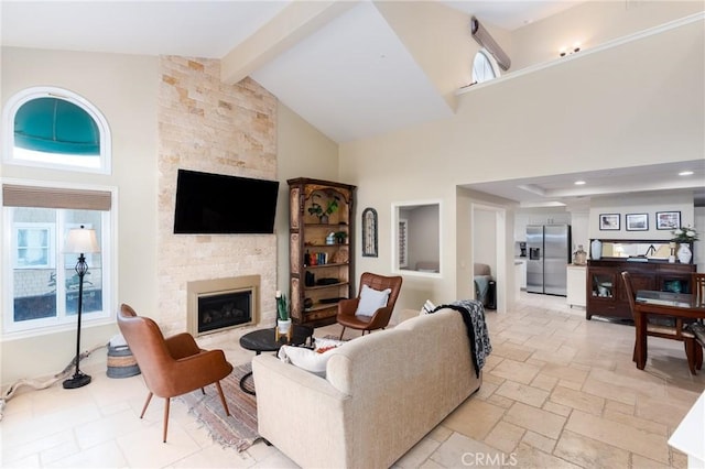 living room with high vaulted ceiling, stone tile flooring, a fireplace, and beamed ceiling