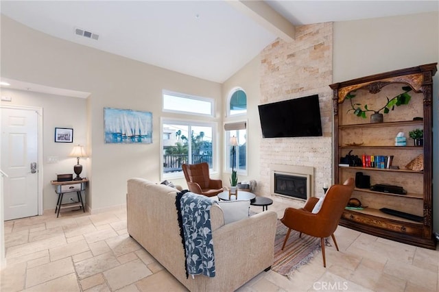 living area featuring visible vents, beamed ceiling, stone tile flooring, a stone fireplace, and high vaulted ceiling