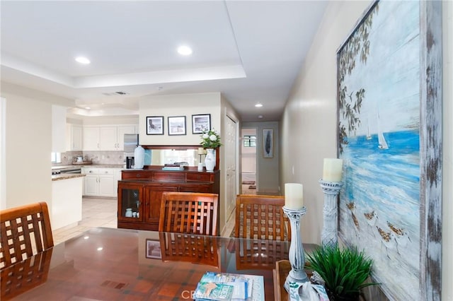 interior space featuring recessed lighting, a raised ceiling, and visible vents