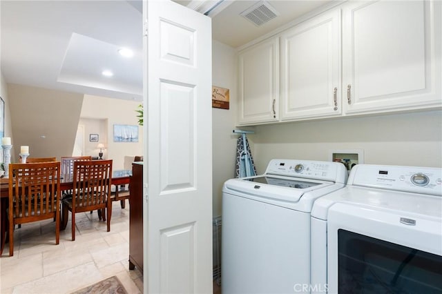 laundry room with stone finish flooring, cabinet space, independent washer and dryer, and visible vents