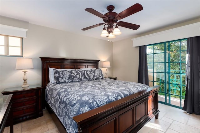 bedroom with ceiling fan, multiple windows, stone tile flooring, and access to exterior