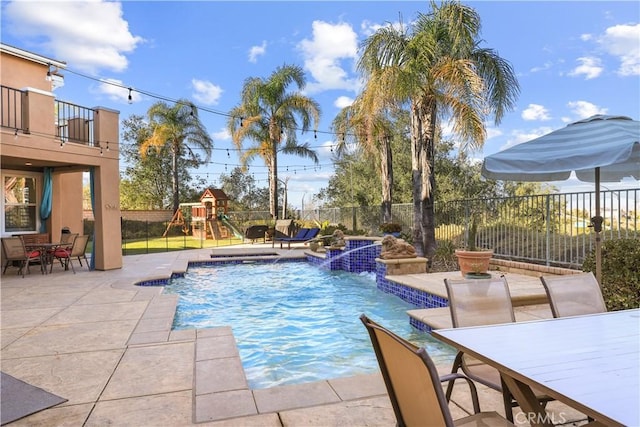 view of pool with a fenced backyard, a playground, outdoor dining area, a fenced in pool, and a patio area