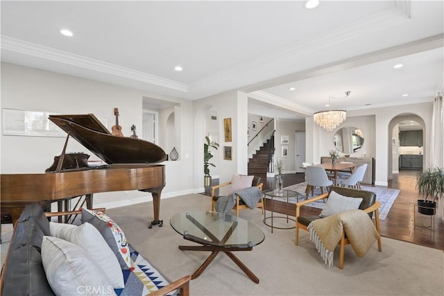 living room featuring crown molding, baseboards, stairway, recessed lighting, and arched walkways